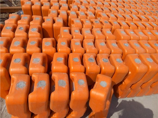 zdjęcie przedstawiające pomarańczowe plastikowe nóżki tymczasowego ogrodzenia zakrywające betonowy otwór