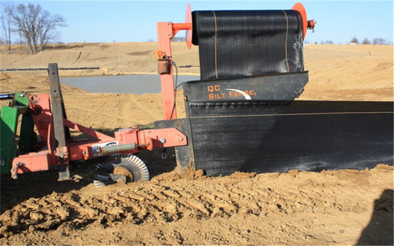 the silt fence installed by machine near river