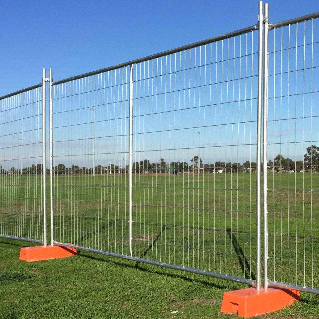 une photo d'une clôture temporaire de 3,3 m de long installée avec des pieds et des pinces sur la prairie