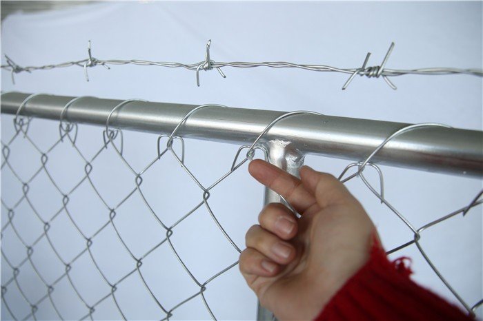 a picture of temporary chain link fence with top barbed wire