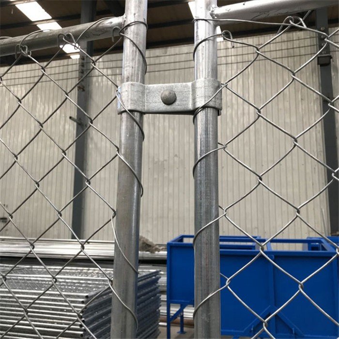 Las abrazaderas de acero conectaron dos cercas temporales de alambre.