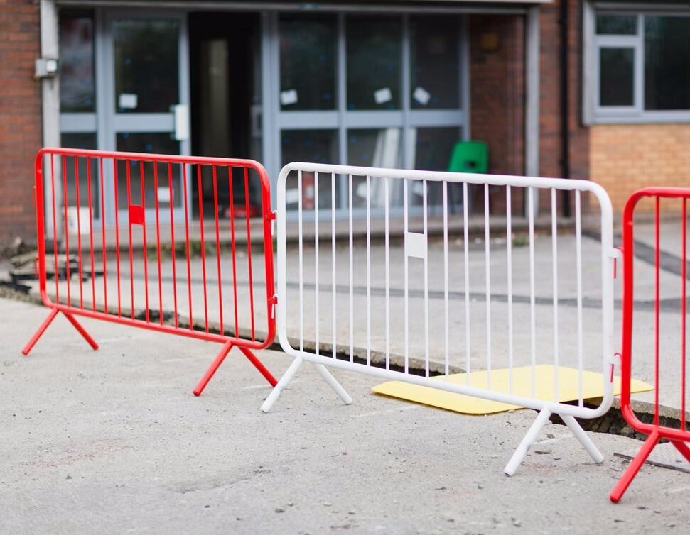 The powder coated red cropwd barriers are connected with white steel barrier