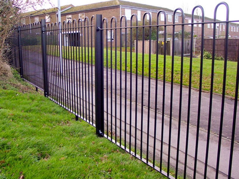 Powder coated black metal hoop top fencing around house