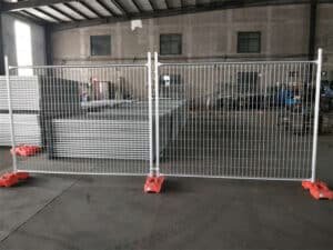 Two hot dipped galvanized temporary fence panels installed with feet and clamps.