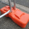 A orange temporary fence feet connect two panels