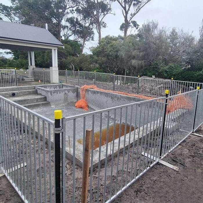 Tymczasowe ogrodzenie wokół placu budowy basenu
