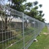 The galvanized roll top BRC fence around a house.