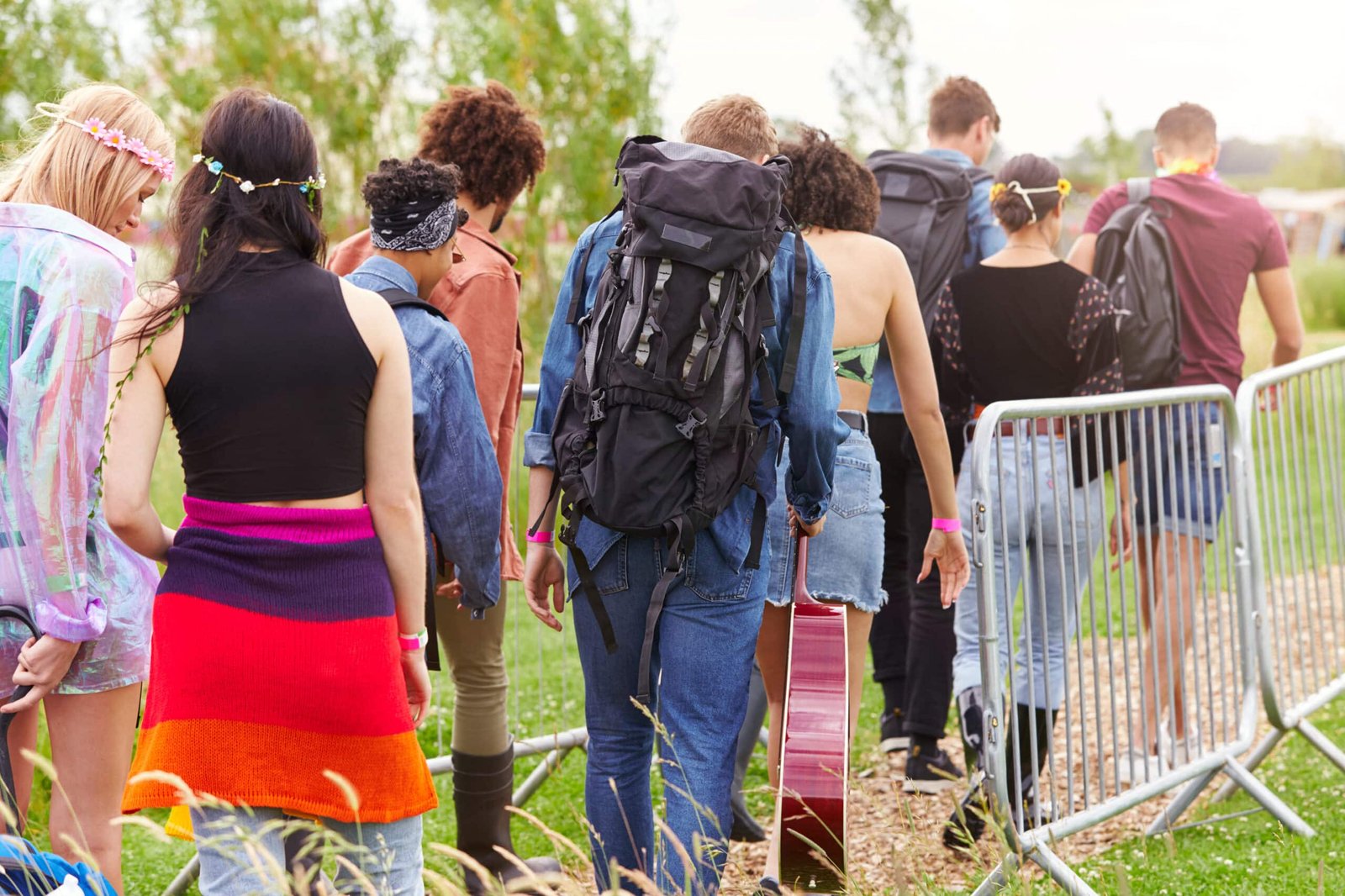 Menschen betreten das Musikfestival und gehen durch Sicherheitsbarrieren