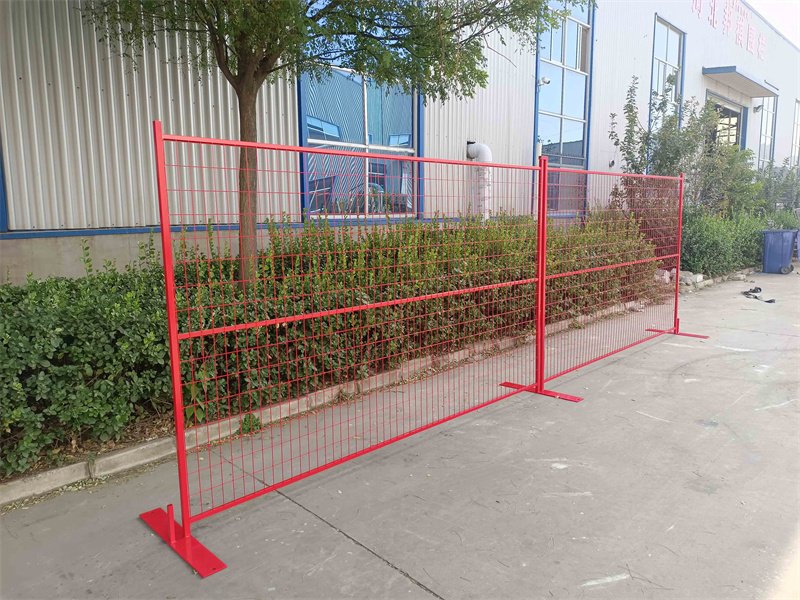 Tymczasowe ogrodzenie budowlane Row of Canada z plastikowymi nóżkami i tkaniną zacieniającą, używane do zarządzania ruchem podczas budowy dróg.
