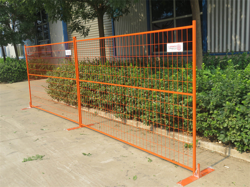 Vividly colored powder-coated temporary construction fence in orange, securing a residential renovation area in Canada.