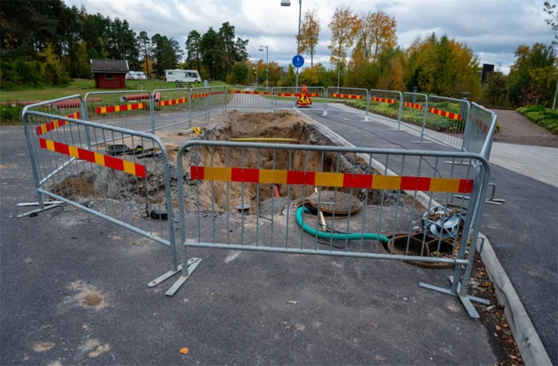 Crowd control barriers with reflective signs at night to direct traffic and enhance visibility in low-light conditions.