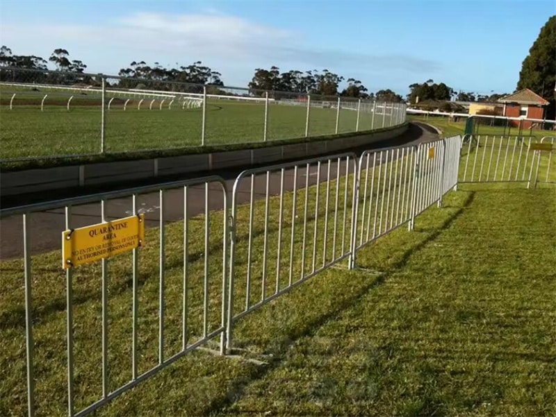 Portable crowd control barriers with flat feet bases positioned around a construction site to ensure public safety.