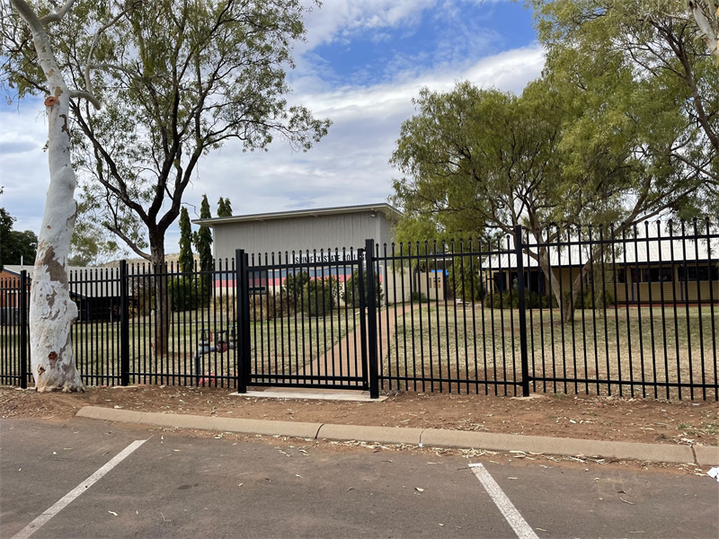 Weatherproof steel picket fence with a powder-coated finish, installed along a busy city sidewalk for pedestrian safety.