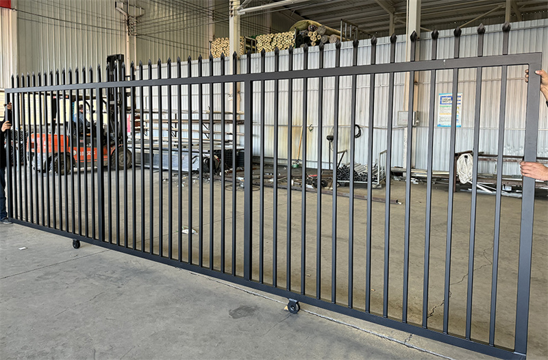 The sliding gate of black powder coated steel garrison fence.