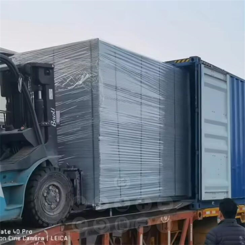 Stack of flat-packed Canada temporary construction fence panels ready for shipment, featuring pre-galvanized and powder-coated finishes.