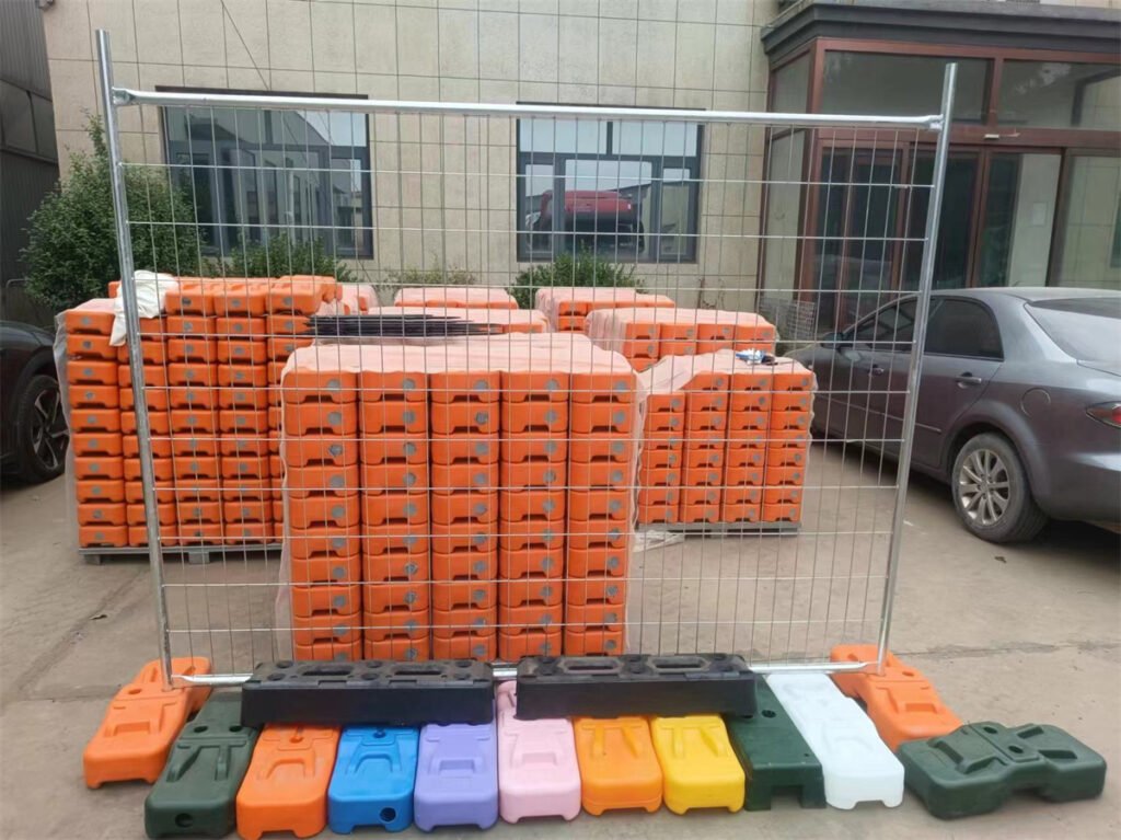 A display of temporary fencing panels with colorful plastic feet and rubber bases, showcasing the variety of products available for construction sites. The fencing panels are stacked neatly in the background, highlighting the efficient packaging and storage solutions provided by DB Fencing.