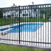 Black aluminum flat top fence with decorative rings installed around a residential swimming pool, providing safety and a stylish appearance.