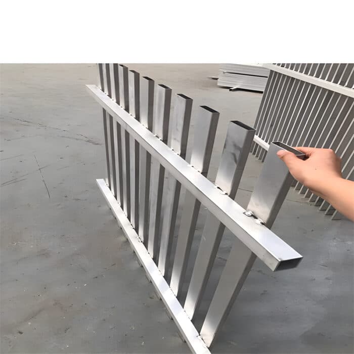 Silver aluminium blade fence panel held by a person, highlighting the lightweight and sturdy construction of the vertical slats.