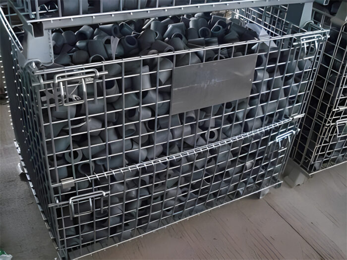 Collapsible mesh stillage cage filled with black rubber components, highlighting its storage capacity.