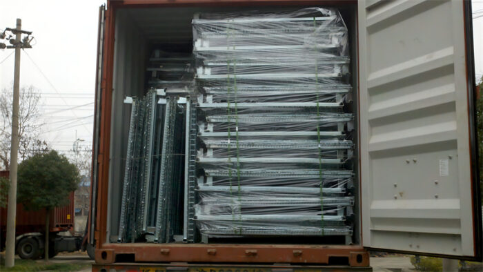 Container filled with neatly stacked and wrapped collapsible stillage cages ready for shipment.