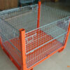 Orange and galvanized steel stillage cage with mesh sides, displayed in an indoor setting.