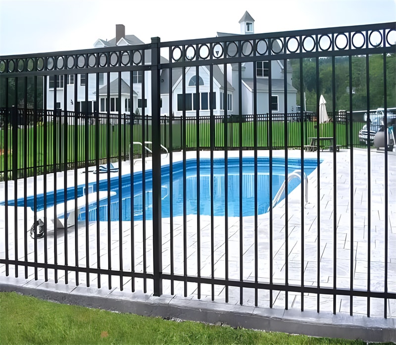 Black aluminum flat top fence with decorative rings installed around a residential swimming pool, providing safety and a stylish appearance.