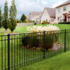 A beautifully landscaped residential property with black aluminum spear top fencing.