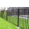 Black aluminum fence installed around a lush garden with blooming flowers and tall trees, enhancing both security and aesthetics.