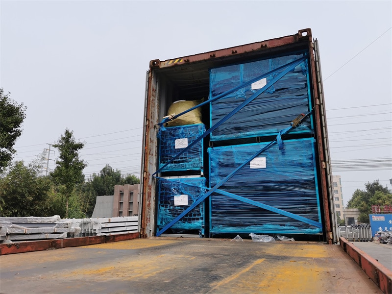 Shipping container loaded with blue-wrapped welded wire fence panels, securely fastened with blue straps, ready for export. The container is open, showing the well-organized packaging and labeling for efficient transportation.