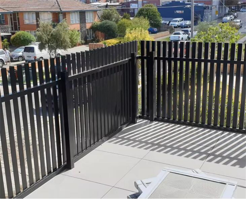 Balcony enclosed with black aluminium blade fencing, providing a secure and aesthetically pleasing barrier with a view of the street.