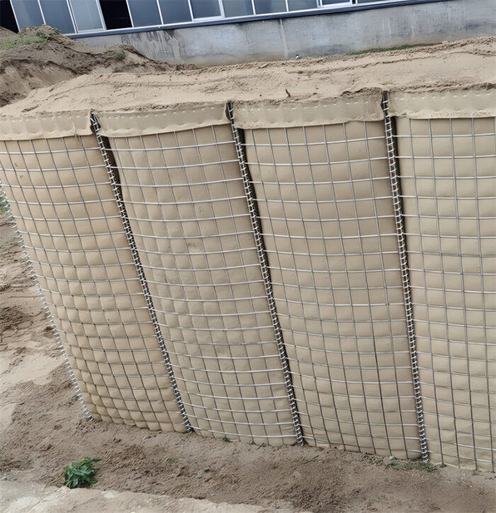 Close-up of a large, reinforced Hesco barrier wall at a defensive site.