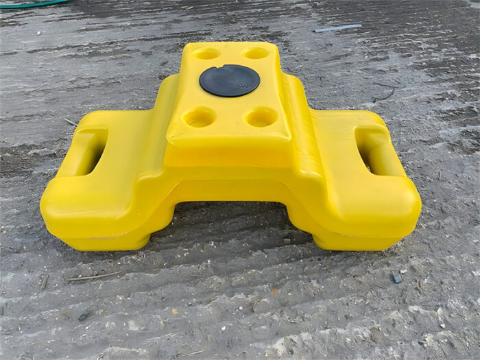 A yellow ballast block is placed on the ground.