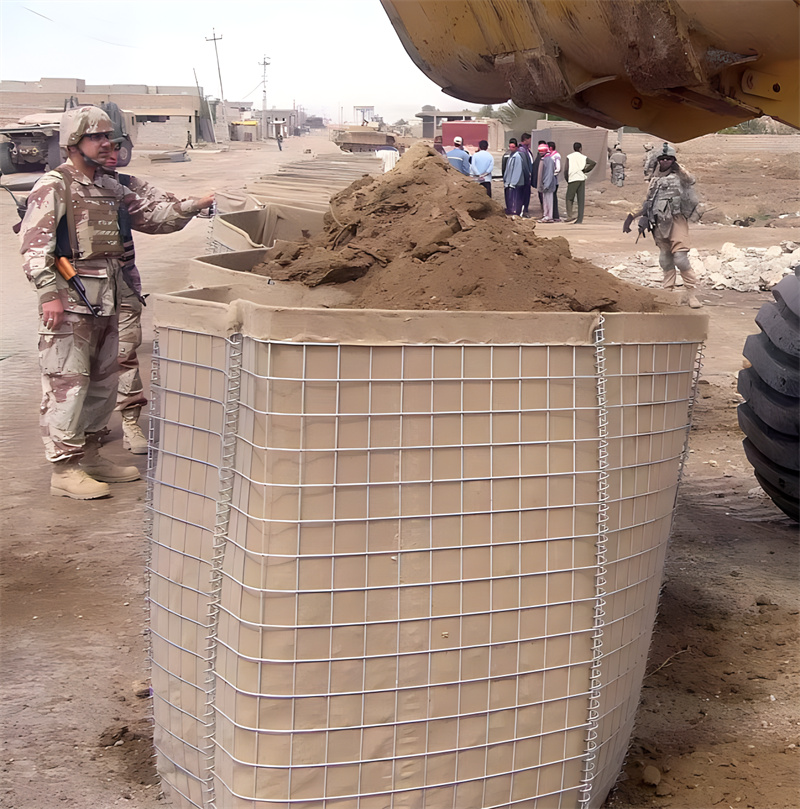 Military personnel filling a Hesco barrier with sand using heavy machinery during a field operation, demonstrating the barrier's application in creating durable, protective barriers for defense purposes in conflict zones.