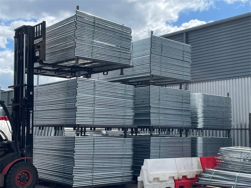 Stacked temporary fencing panels ready for transport, showcasing galvanized steel construction.