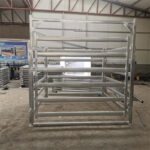 A partially assembled frame structure made of galvanized steel panels, showcasing a modular design suitable for stockyards or portable fencing.