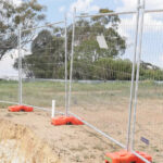 Secure temporary fencing installation around a construction site.