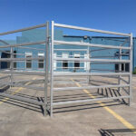 Steel horse panels arranged in a square configuration, ready for assembly in an equestrian facility.