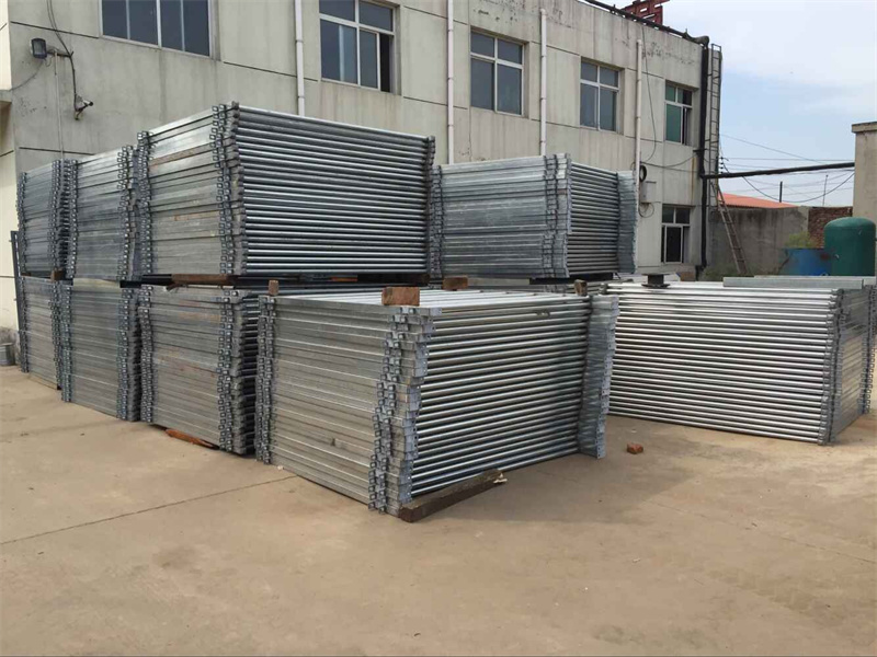 Stacks of galvanized portable horse corral panels neatly arranged outside a factory, showcasing their durability and readiness for bulk shipping.