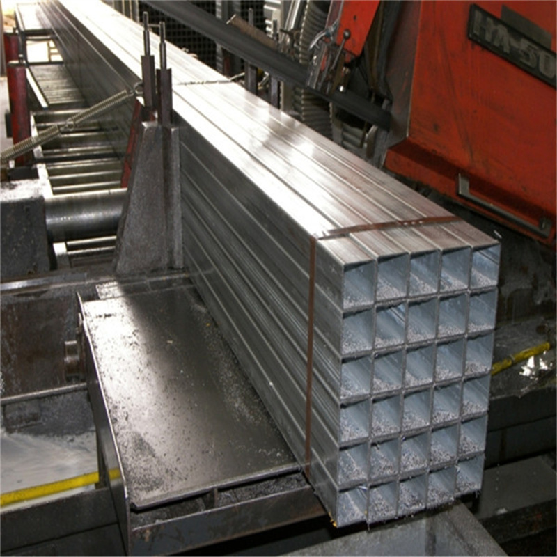 Rows of galvanized steel tubing being prepared for horse panels in a manufacturing facility.