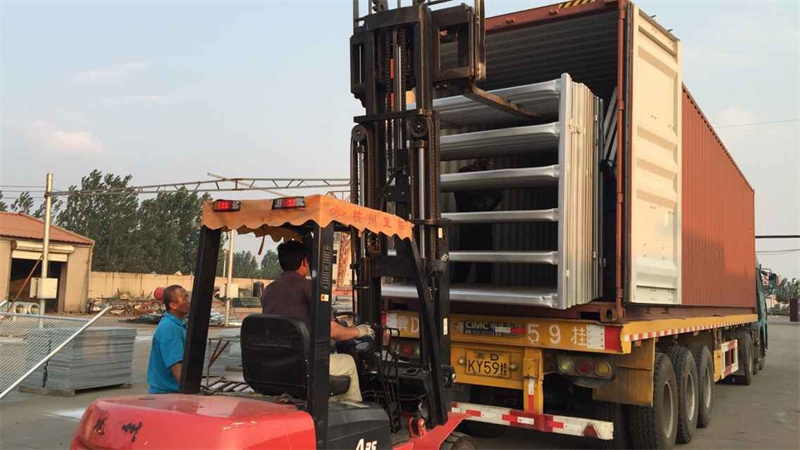 Forklift loading a stack of heavy-duty galvanized horse panels into a shipping container, showcasing the preparation process for bulk deliveries.