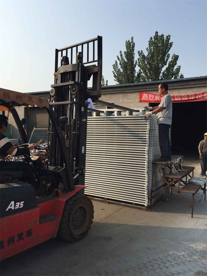 A forklift loading galvanized steel horse panels for transport, showcasing the efficiency in handling equestrian fencing.