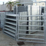 Stacked galvanized horse panels and gates at a warehouse, ready for distribution, showcasing their sturdy and durable construction.