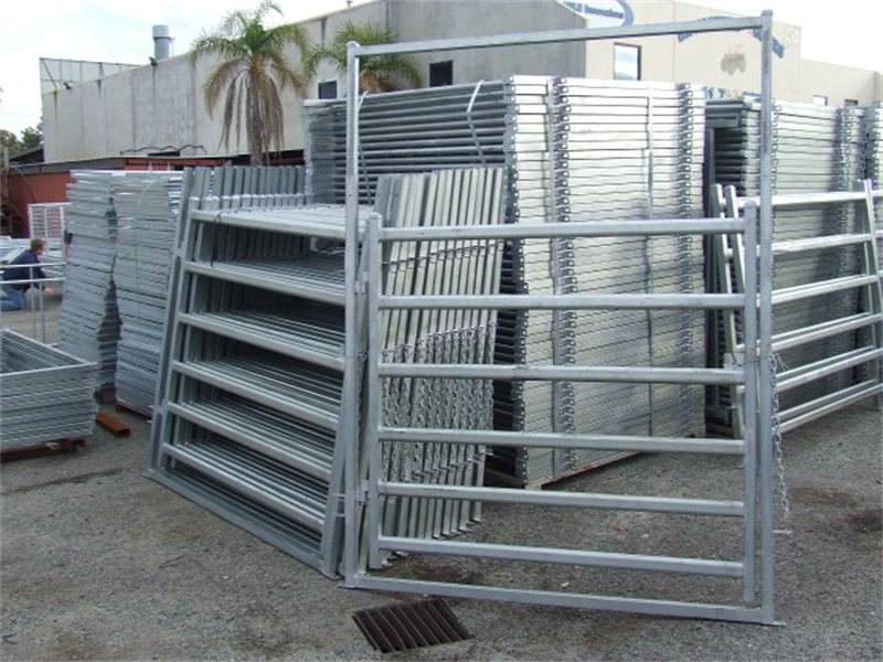 Stacked galvanized horse panels and gates at a warehouse, ready for distribution, showcasing their sturdy and durable construction.