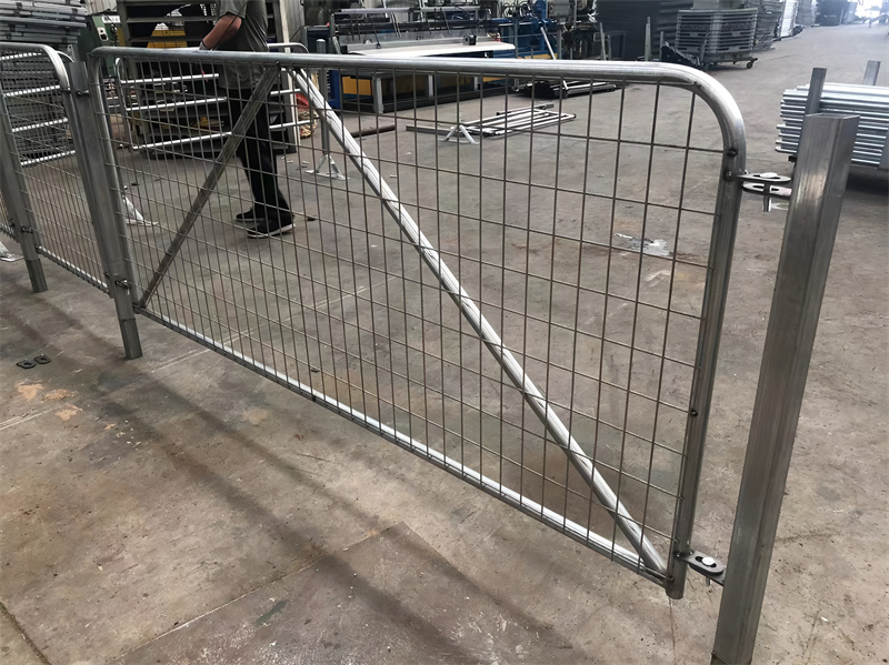 Galvanized mesh farm fence gate in a workshop setting, showcasing the quality and design of the gate before installation.