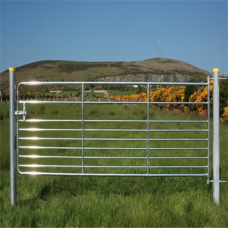 A close-up of a galvanized steel farm gate with a scenic hillside background, emphasizing its practical use and aesthetic appeal on a farm.