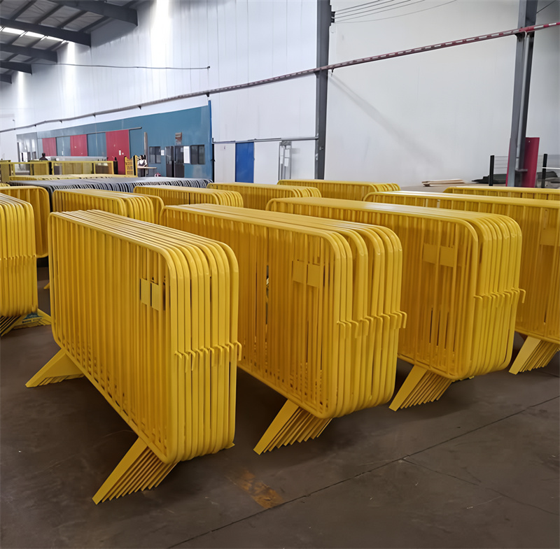 collection of yellow steel barricades stacked neatly in a warehouse, ready for use, showcasing their sturdy design and vibrant color.