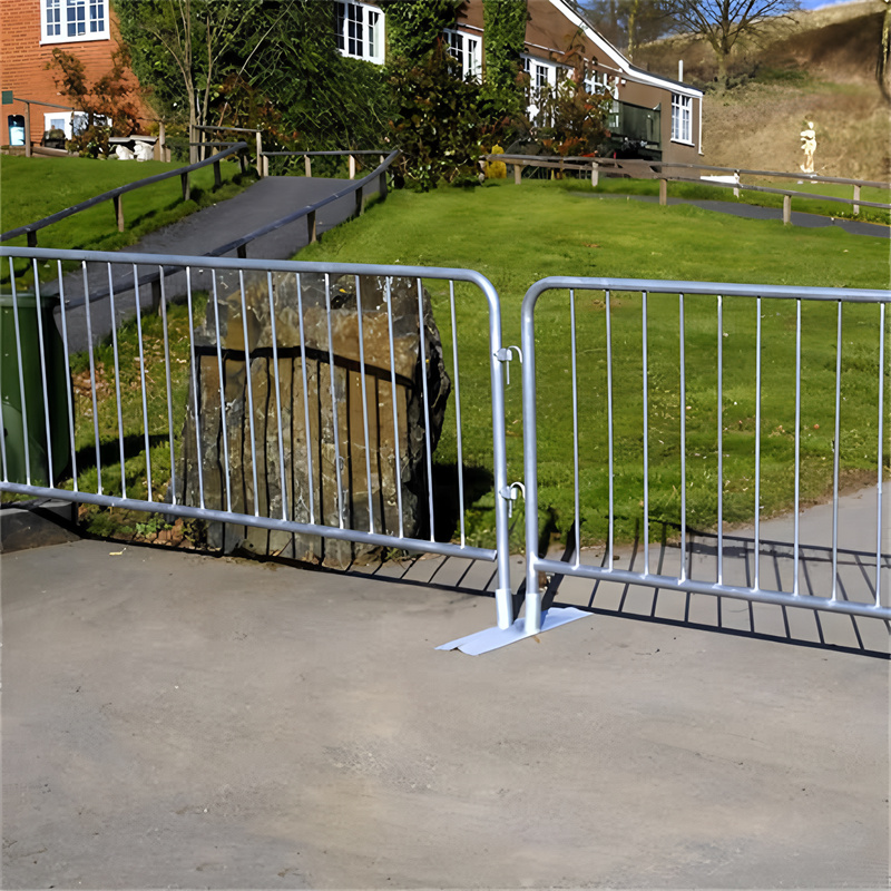 Steel barriers installed in an outdoor setting, surrounding a green lawn to provide safety and containment for events.