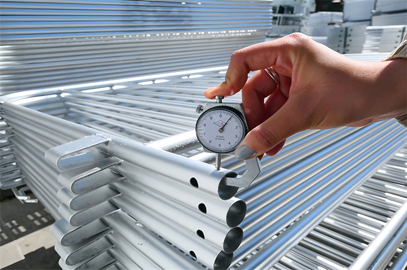 A close-up of a person using a caliper to measure the thickness of steel barricades, emphasizing quality control during manufacturing.