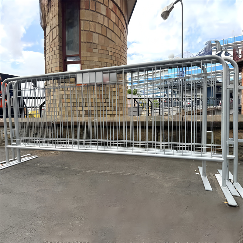 A crowd control barrier positioned in an urban area, showcasing its structure near a building with a modern design.