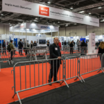 A trade show setup featuring crowd control barriers to guide attendees and create designated areas for different exhibitors.